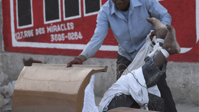 Erdbeben in Haiti: Ein Mann zerrt an einem Toten, um dessen Sarg zu stehlen