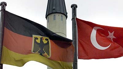 Die deutsche und die türkische Fahne vor einem Minarett in Gelsenkirchen