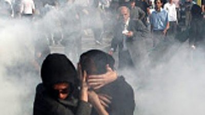 Präsidentenwahl in Iran: Zwei Iranerinnen schützen sich bei Protesten am Samstag vor Rauchschwaden oder Tränengas.