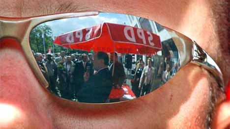 Peer Steinbrück  spiegelt sich in Düsseldorf beim Straßenwahlkampf in der Brille eines Sicherheitsbeamten.