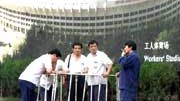 Olympische "Protz"-Spiele: Pekinger Arbeiter vor einem Staionsposter.
