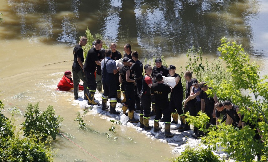 Emergency services workers reinforce a barrier with sand bags on the right bank of the Vistula River in Warsaw