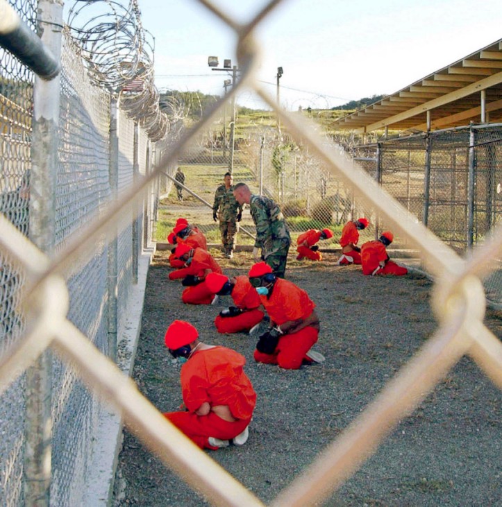 File photo shows detainees sitting in a holding area watched by military police at Camp X-Ray inside Naval Base Guantanamo Bay, Cuba