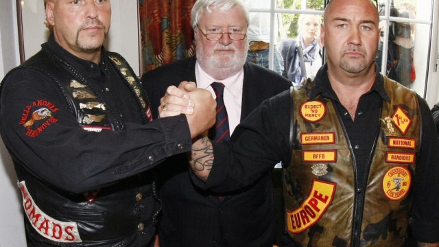 Lawyer von Fromberg watches as Maczollek of MC Bandidos and Hanebuth of Hells Angels shake hands following news conference in Hannover