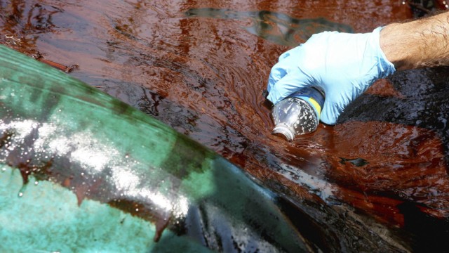 Garret Graves with the Coastal Protection and Restoration Authority collects an oil sample in Pass A Loutre near Venice, Louisiana