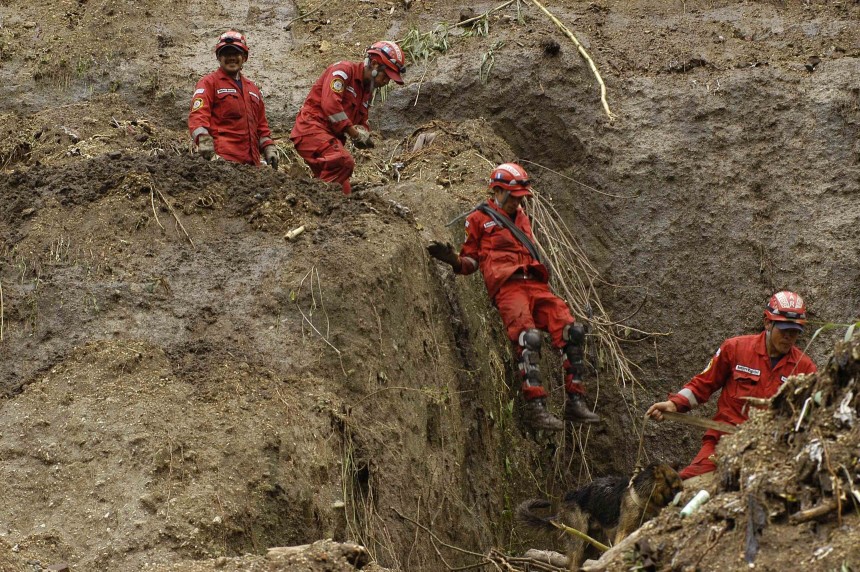 Rescue workers look for landslide victims in a settlement called '19 de Mayo' in Guatemala City