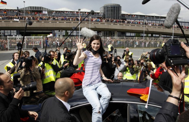 German singer Lena Mayer-Landrut is surrounded by the media as she waves to fans following her arrival at Hanover airport