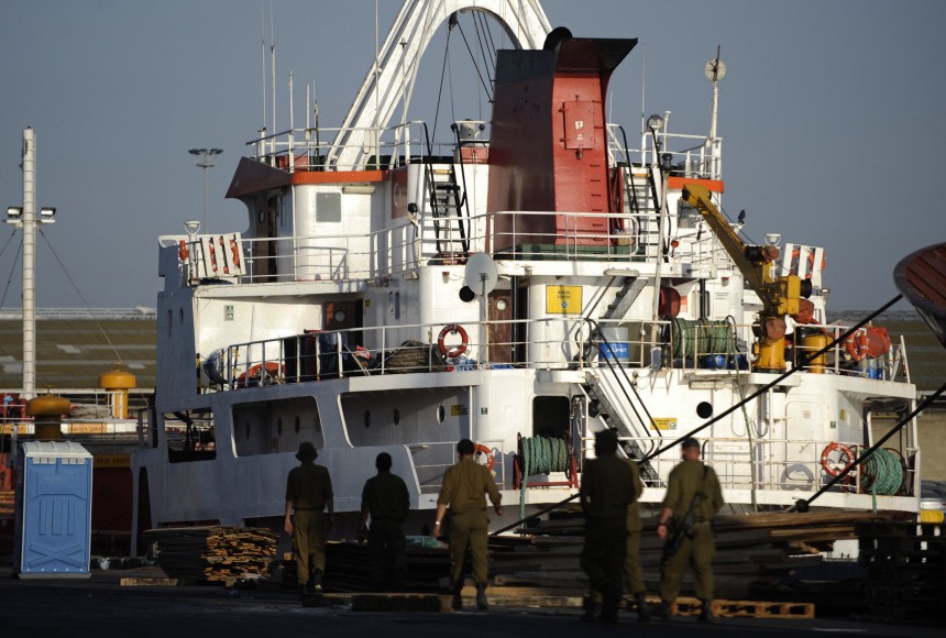 Israeli soldiers walk in front of one of the Gaza-bound ships at the port of Ashdod