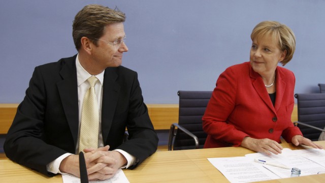 German Chancellor Merkel and Foreign Minister Westerwelle arrive for a news conference in Berlin