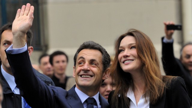 France's President Sarkozy and his wife Carla Bruni-Sarkozy leave Paris polling station after voting in the second round of regional elections