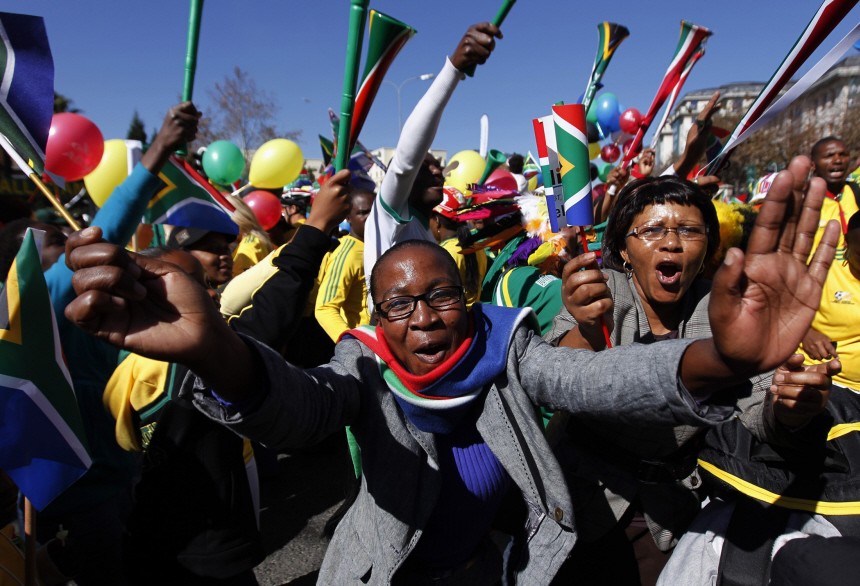 South Africans dance as they cheer during a parade to support the South African soccer team in Sandton