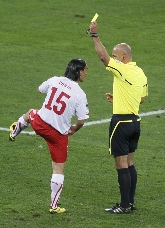 Switzerland's Yakin gets a yellow card from referee Webb of England during a 2010 World Cup Group H match against Spain at Moses Mabhida stadium in Durban