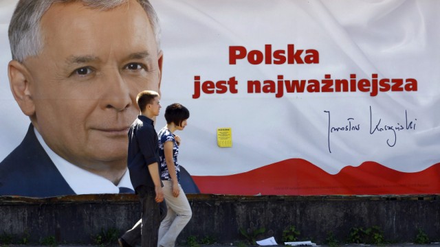 People pass by an election poster of Jaroslaw Kaczynski, presidential candidate of Poland's Law and Justice Party (PiS) in Warsaw