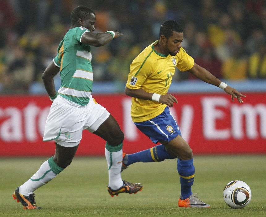 Ivory Coast's Emmanuel Eboue fights for the ball with Brazil's  Robinho during their 2010 World Cup Group G soccer match at Soccer City stadium in Johannesburg