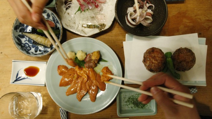 People share dishes at Japanese traditional 'Izakaya' pub named Saiki in Tokyo