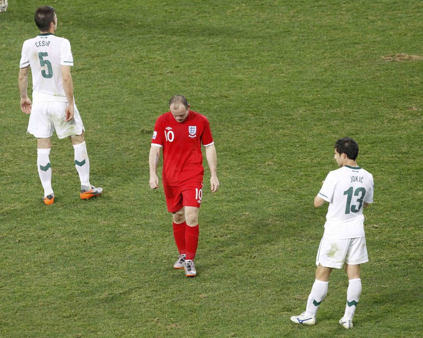 England's Rooney walks off the pitch between Slovenia's Cesar and Jokic as after being substituted during the 2010 World Cup Group C soccer match