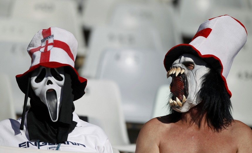 Fans wear masks as they wait for the start of the 2010 World Cup second round soccer match between Germany and England in Bloemfontein