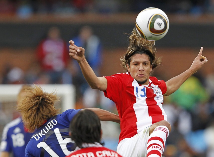 Paraguay's Vera jumps for the ball next to Japan's Okubo during the 2010 World Cup second round soccer match at Loftus Versfeld stadium in Pretoria