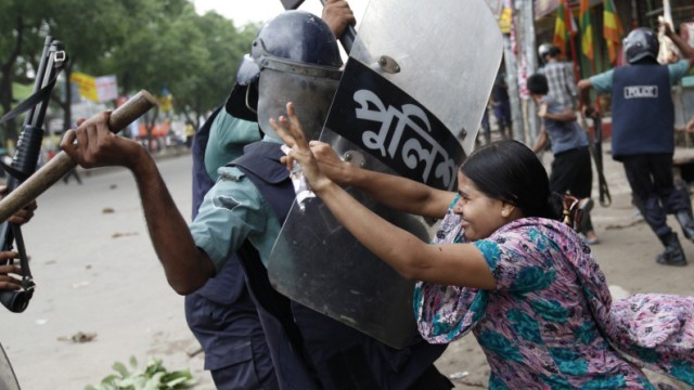 Rahela Akhter, a garment worker, tries to resist beating from the police during a protest in Dhaka