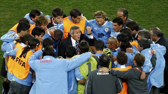 Uruguay's head coach Oscar Washington Tabarez talks to his team before the start of extra time at Soccer City stadium