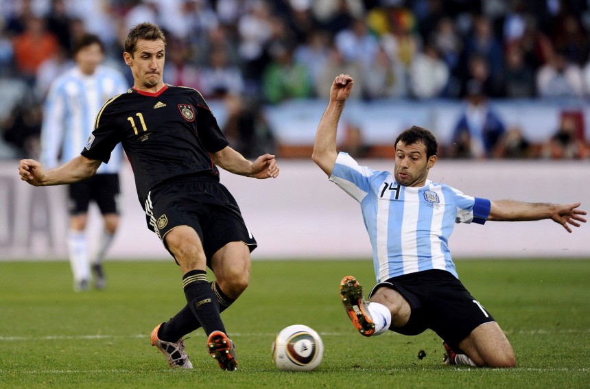 Argentina's Mascherano goes in for a tackle on Germany's Klose during their 2010 World Cup quarter-final soccer match at Green Point stadium in Cape Town