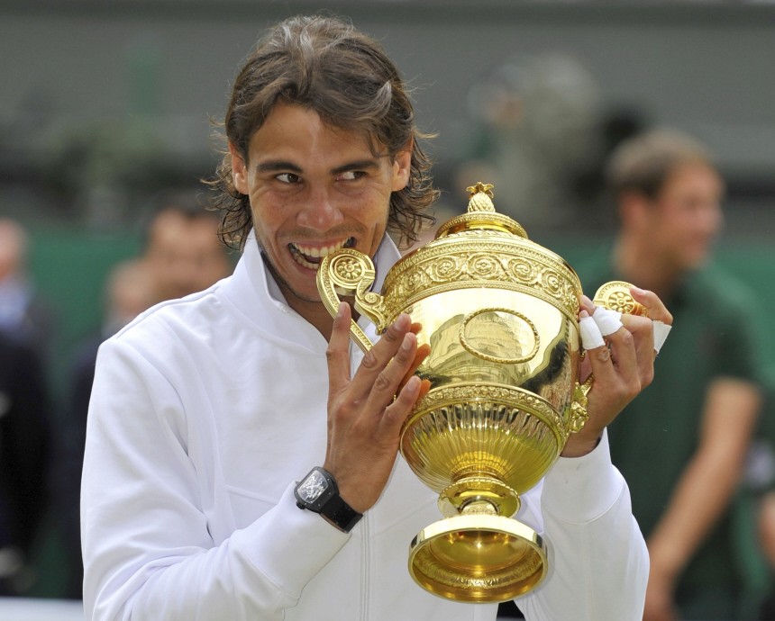 Spain's Rafael Nadal bites the winners trophy as he poses for a photograph after defeating Tomas Berdych of the Czech Republic in the men's singles final at the 2010 Wimbledon tennis championships in London