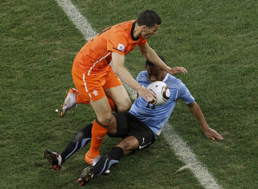 Netherlands' Khalid Boulahrouz fights for the ball with Uruguay's Alvaro Pereira during their 2010 World Cup semi-final soccer match at Green Point stadium in Cape Town