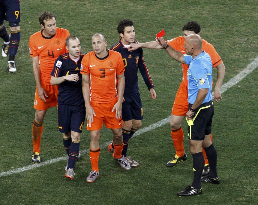 Referee Webb shows the red card to Netherlands' Heitinga during their 2010 World Cup final soccer match at Soccer City stadium in Johannesburg