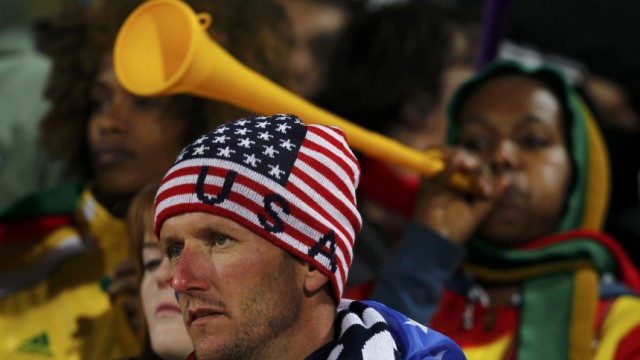 A U.S. fan looks on as a Ghana fan blows a vuvzela during the 2010 World Cup second round match between United States and Ghana in Rustenburg