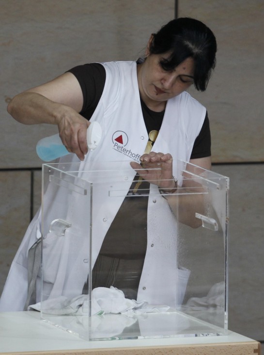 A cleaning woman cleans the ballot-box before the election of the federal state premier of the western German state of NRW in Duesseldorf