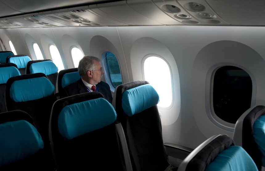 A Boeing employee sits next to a tinted window on the Boeing 787 Dreamliner at Farnborough airport in Farnborough, southern England