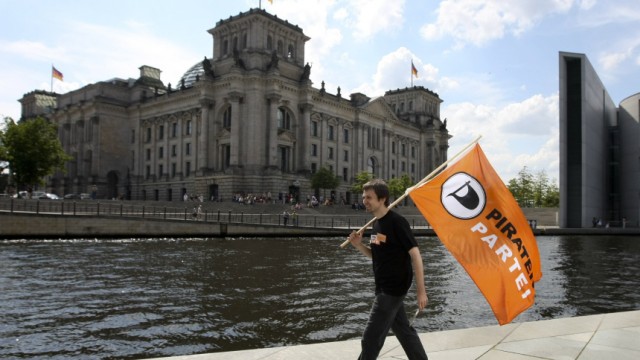 Member of Pirate Party walks in front of Reichstag as part of its campaign for September general election in Berlin