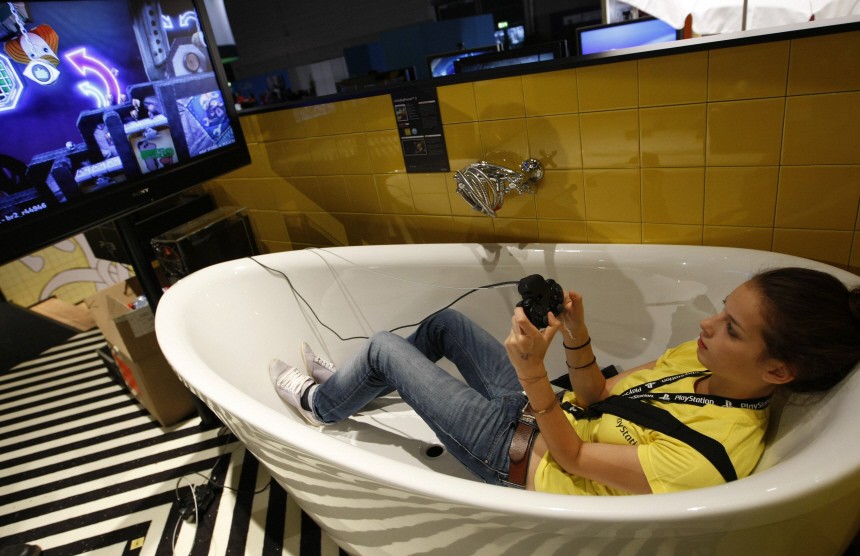 A woman plays with a playstation at their exhibition stand at the Gamescom 2010 fair in Cologne