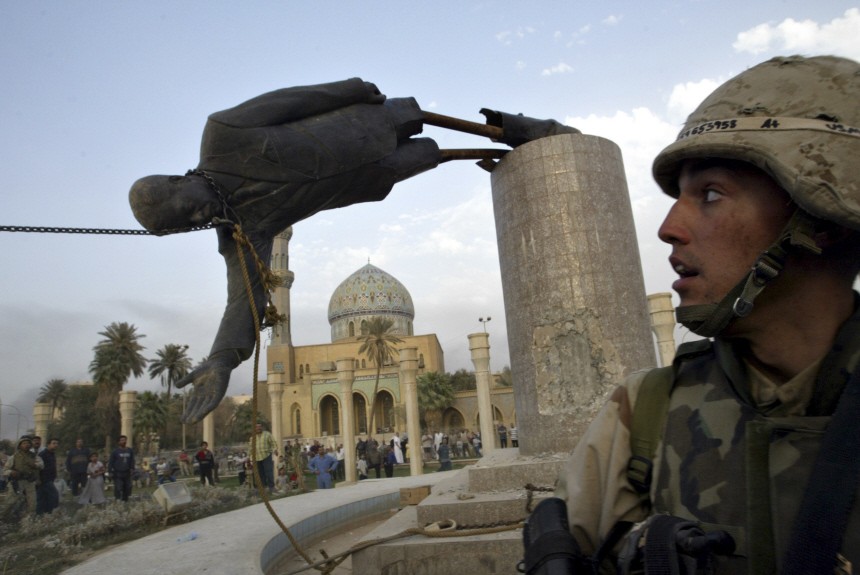 File photo of U.S. Marine Corp assaultman watching a statue of Iraq's President Saddam Hussein falling in central Baghdad