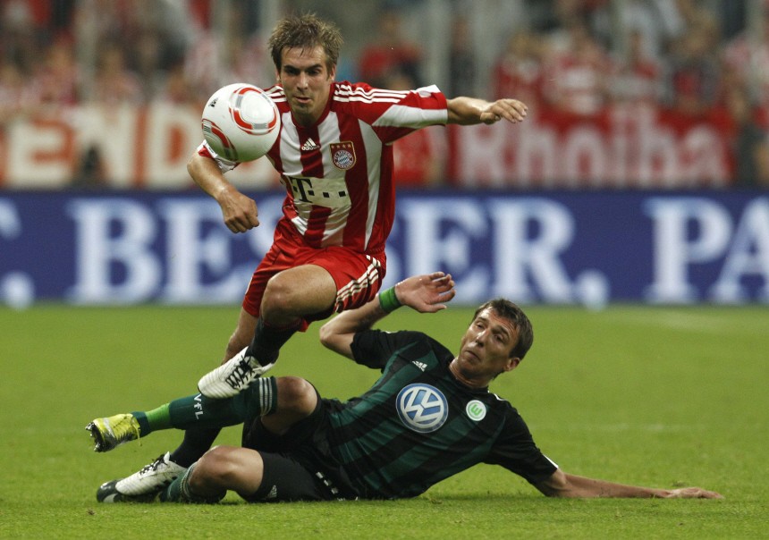 Bayern Munich's Lahm is tackled by Wolfsburg's Mandzukic during Bundesliga soccer match in Munich