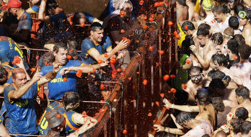 Revellers on a truck throw tomatoes into the crowd during the annual 'Tomatina' (tomato fight) in the Mediterranean village of Bunol