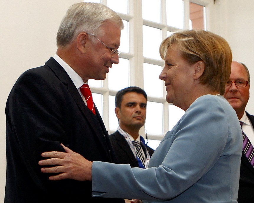 Koch, outgoing Premier of Germany's federal state of Hesse, welcomes German Chancellor Merkel during a reception in Wiesbaden