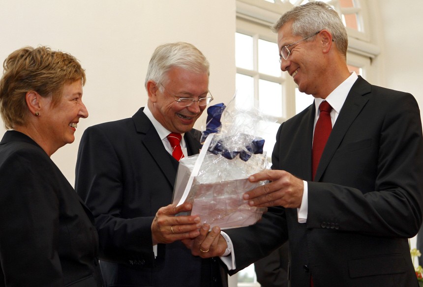 Koch, outgoing Premier of Germany's federal state of Hesse and his wife Anke receive a gift by Frankfurt airport, Fraport, CEO Schulte during a reception in Wiesbaden
