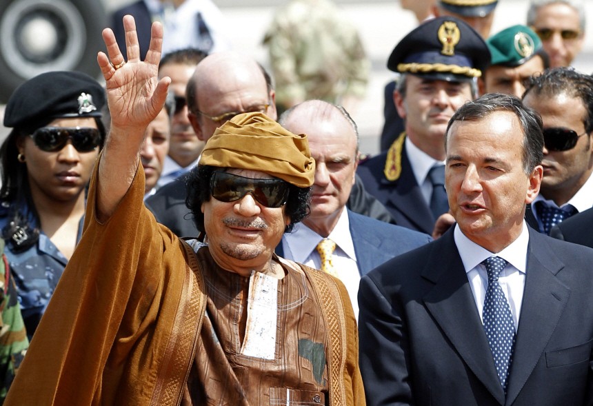 Libyan leader Gaddafi waves next to Italian Foreign Minister Frattini at the Ciampino airport in Rome