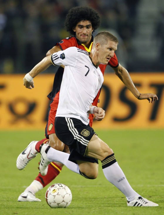Germany's Schweinsteiger is chased by Belgium's Fellaini during their Euro 2012 qualifying soccer match in Brussels