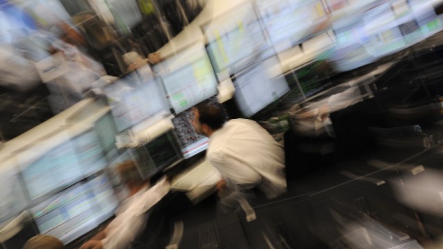 A zoomed picture shows a share trader looking at his screens at the Frankfurt stock exchange during midday trading