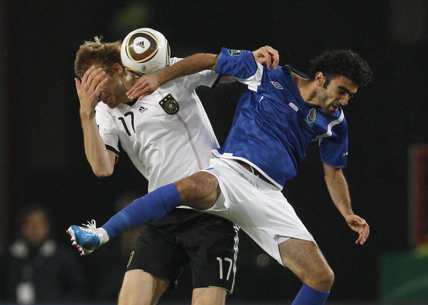 Germany's Per Mertesacker and Azerbaidjan's Vagif Javadof challenge for a ball during their Euro 2012 qualifying soccer match in Cologne