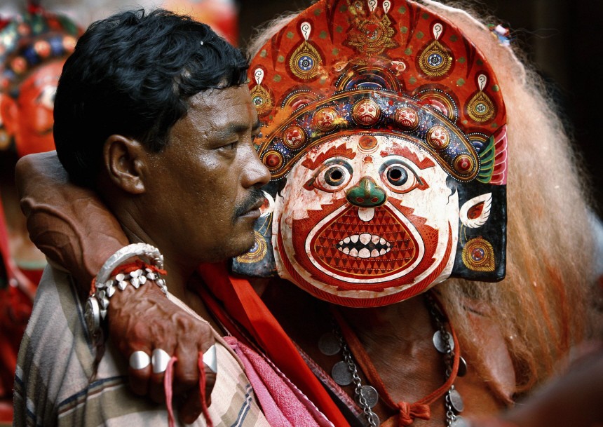 A masked dancer posing as a deity rests during the Nil Barahi mask dance festival in Bode, near Kathmandu