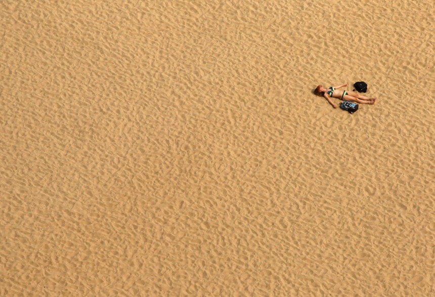 A woman lies on the sands of Haeundae beach in Busan