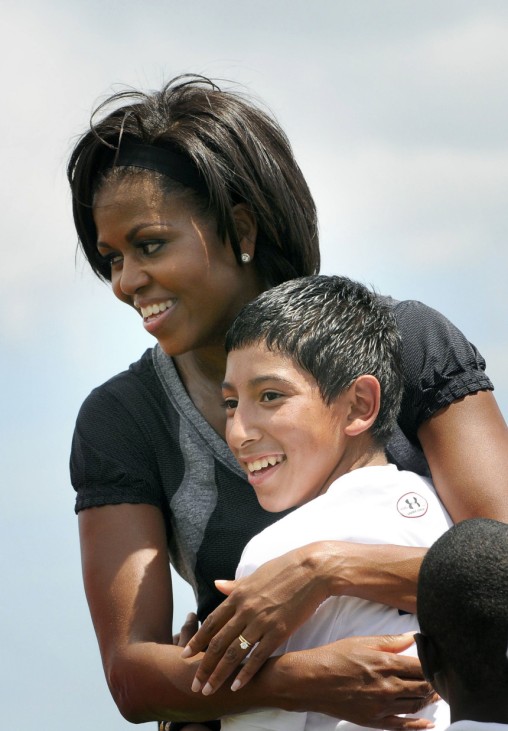 U.S. first lady Obama embraces a child while playing flag football during her 'Let's Move' campaign to fight childhood obesity in New Orleans