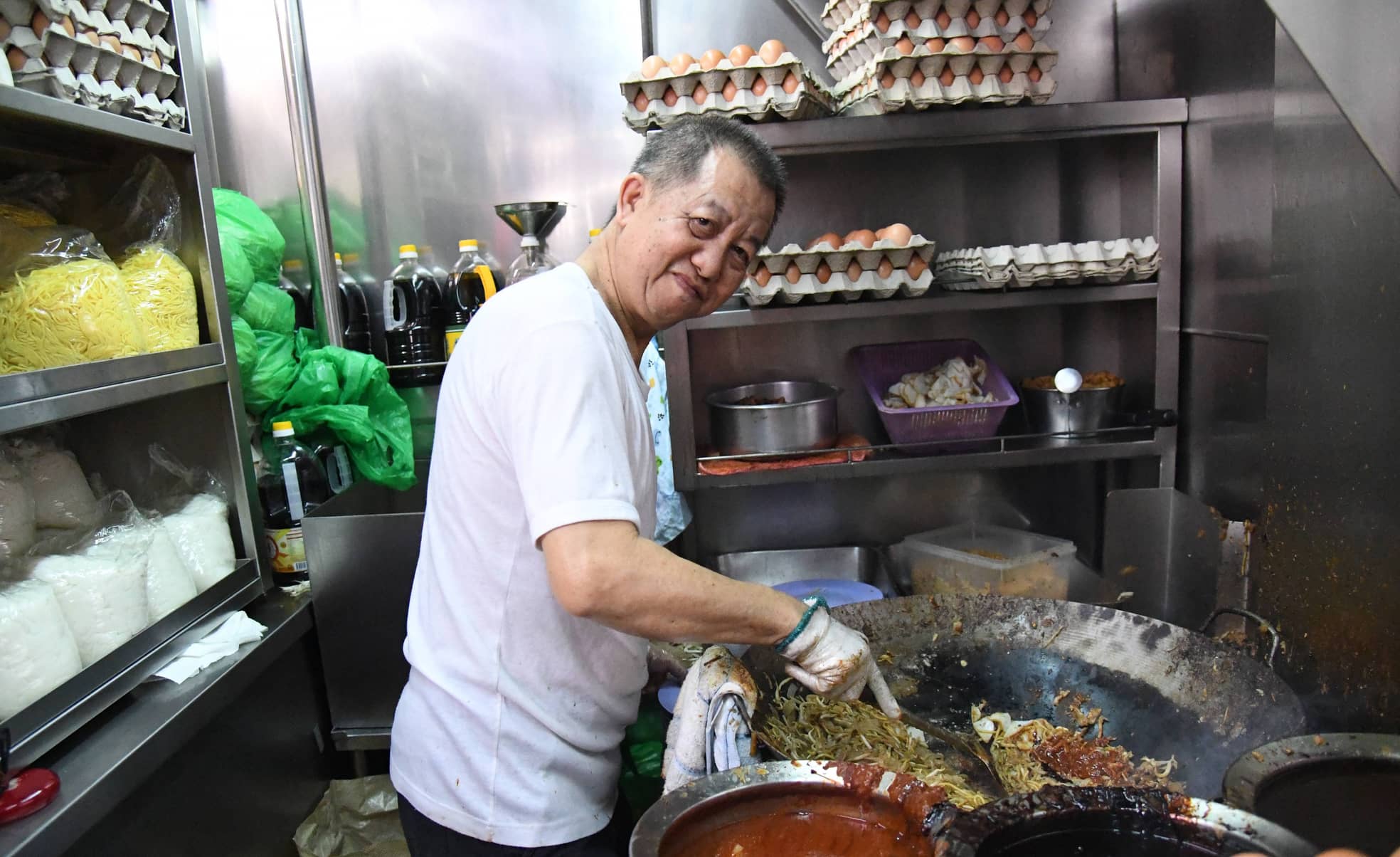 Ein Koch am Wok im Hong Lim Food Centre in Singapore